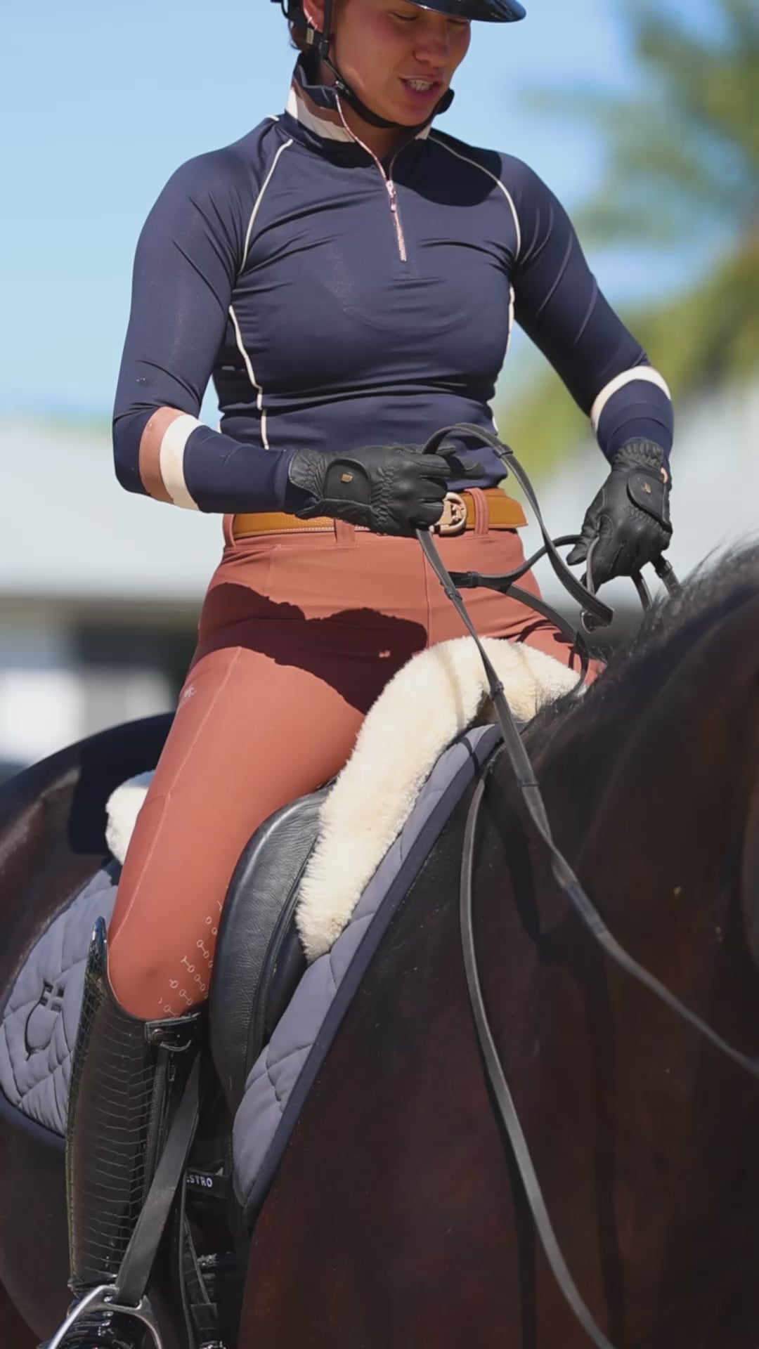 Hope Cooper wearing the Uniqcorn Exceptionnel Midnight Blue Equestrian Sun Shirt and Caramelized Full Seat Hybrid Breeches.